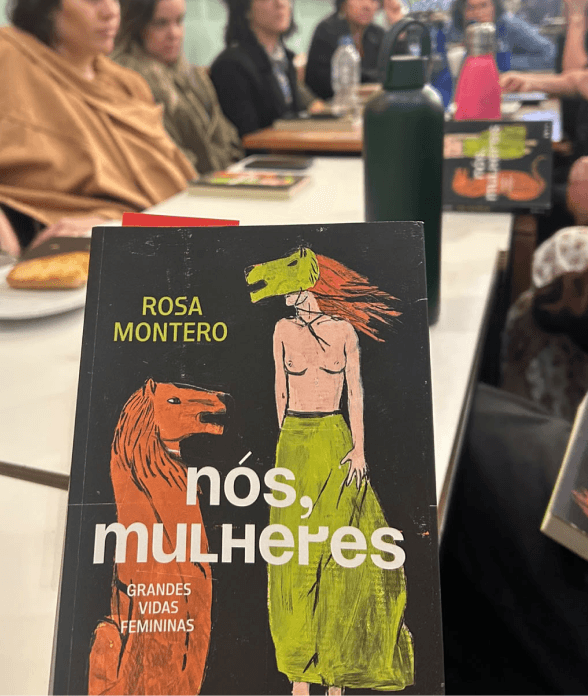 The book nós, mulheres on the table during a club meeting