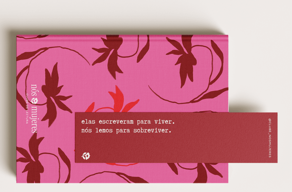 The club's pink notebook with a floral print, next to a bookmark